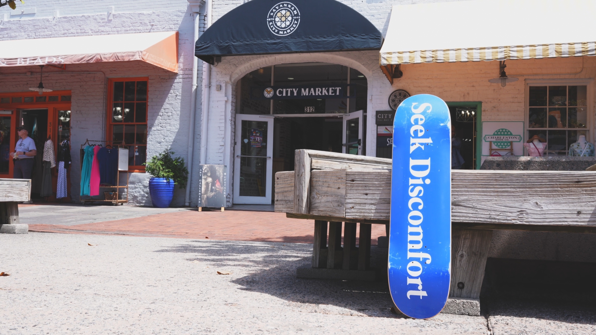 A skateboard leaning on a bench with a building in the background. It is noticeably overexposed.